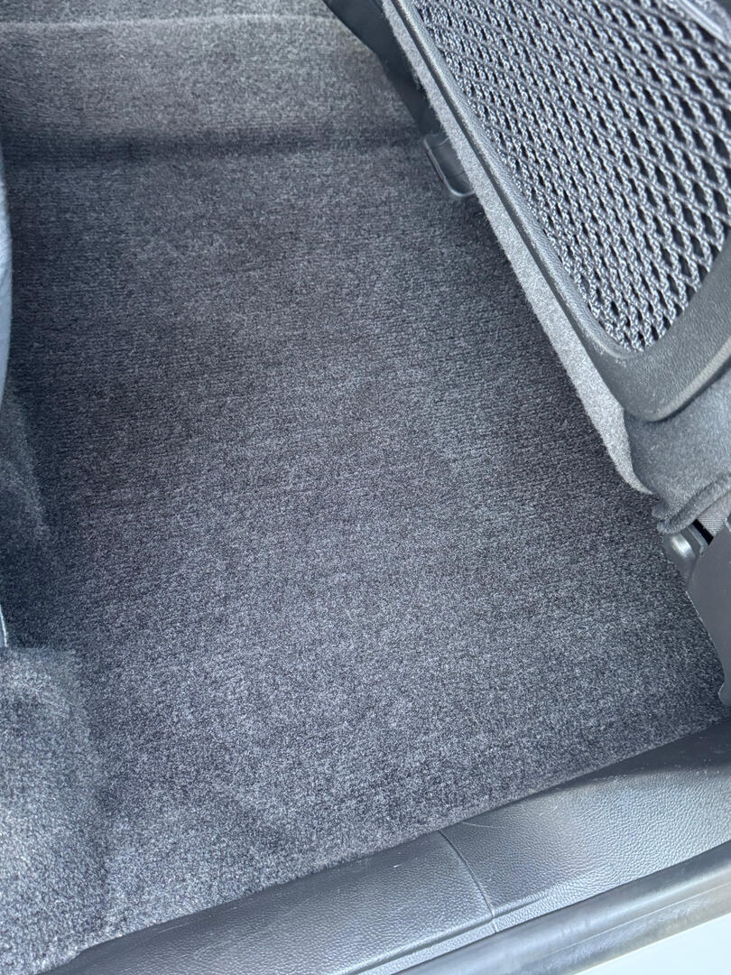 Clean carpet beside the front seat of a detailed vehicle