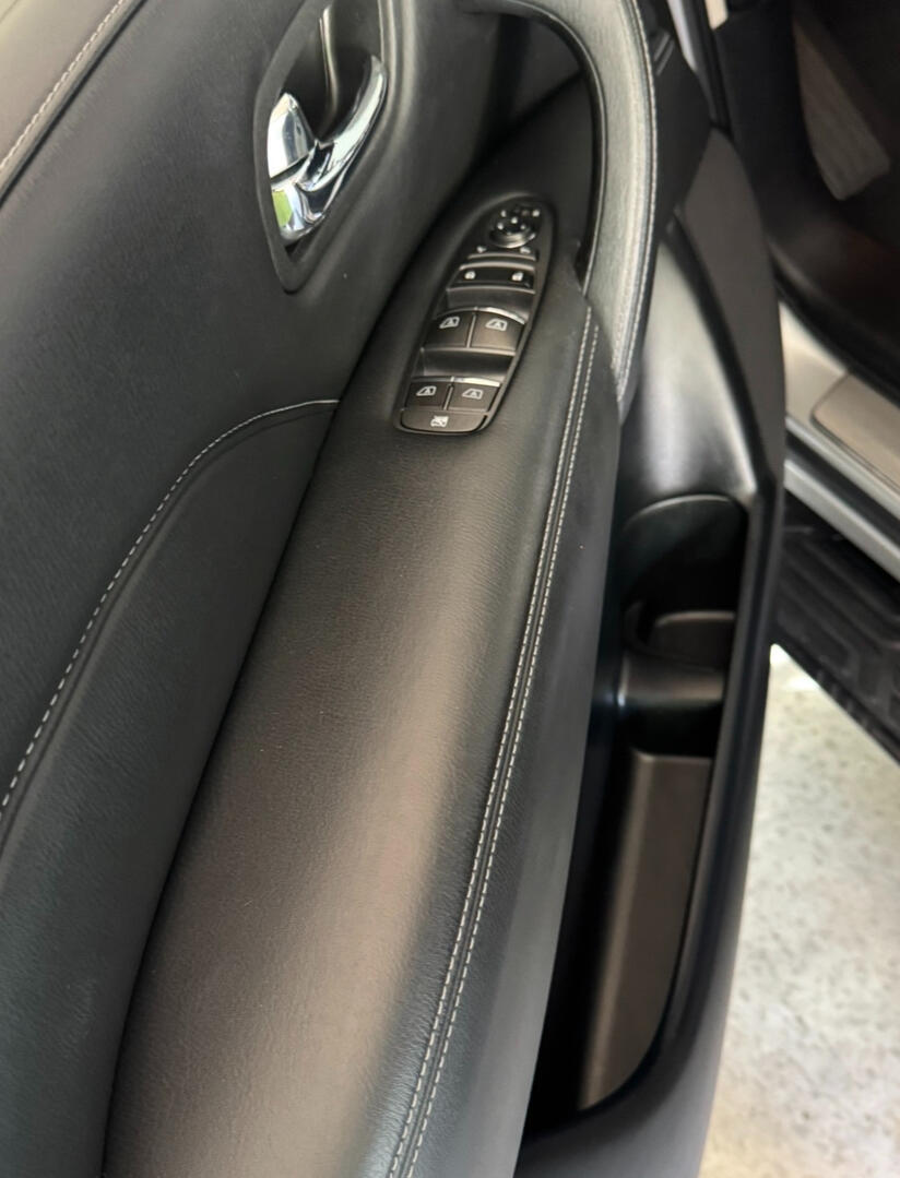 Clean black leather driver-side door panel with window controls